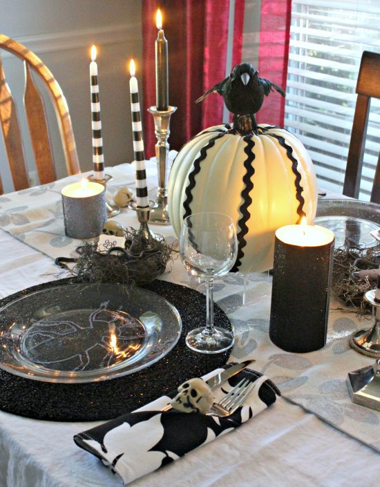 Bug plates, snake nest, pumpkin and skull on table for halloween table decor