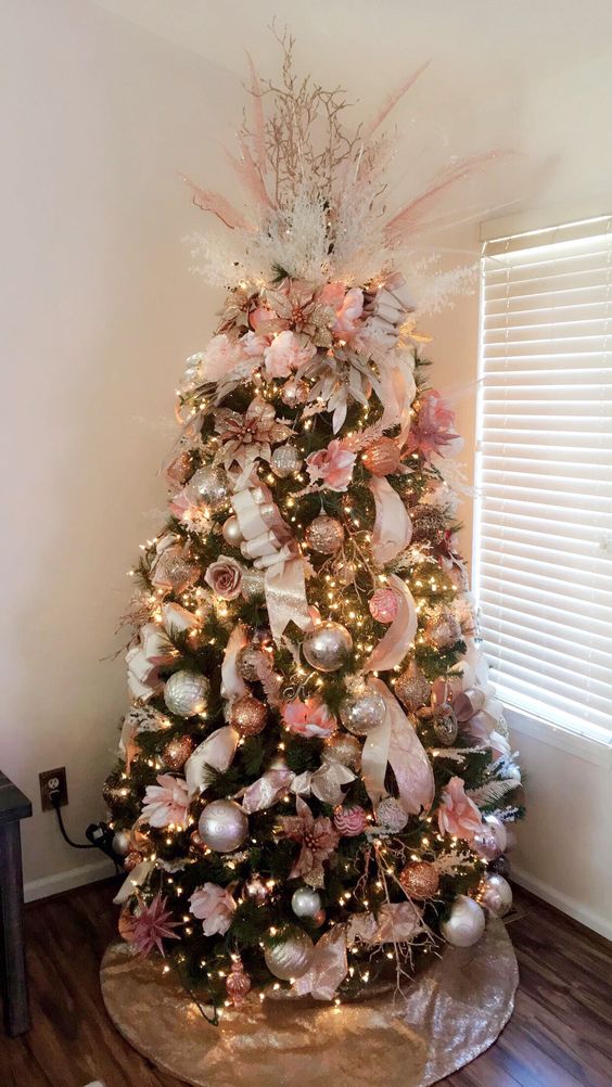 Chic pink flowers and golden ornaments hanging on this Christmas tree