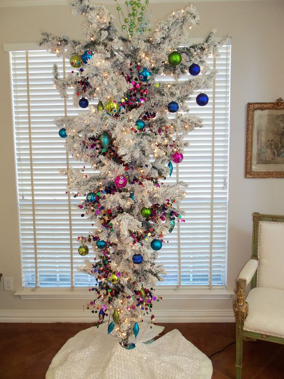 Chic white Christmas tree decorated with colorful ornaments.