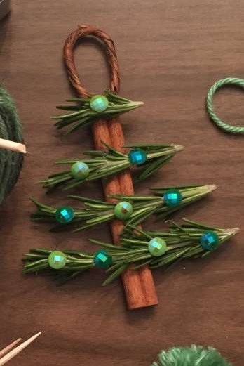 Cinnamon sticks, pine garland, and buttons to make Christmas tree ornament