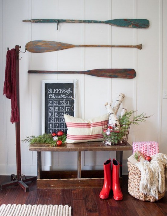 Cottage-style Christmas decoration with long red boots, advent calendar, and greens.