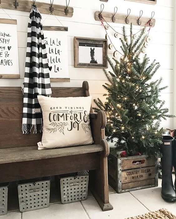 Cozy entryway decoration with Christmas tree, pillow, and plaid cloth. 