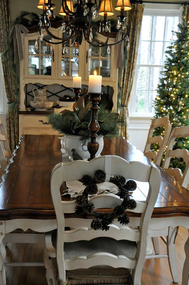 Easy and quick Christmas dining room decor with pinecone wreath on a chair, Christmas tree, and chandelier.