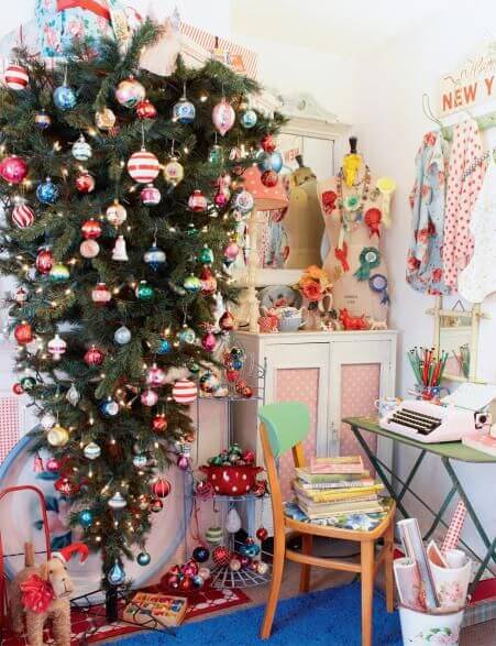 Fresh pastel colors like pink, light blue, orange, and purple are used for decorating this upside-down Christmas tree.