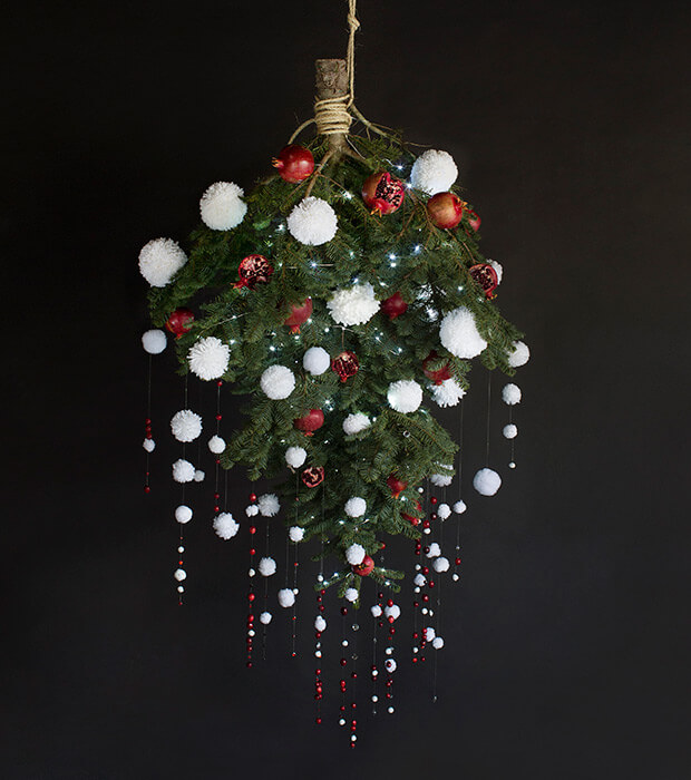 Impressive pom pom decoration of a small upside-down Christmas tree.