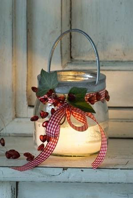 The old pot is decorated with plaid ribbon and hearts and used as a lantern.