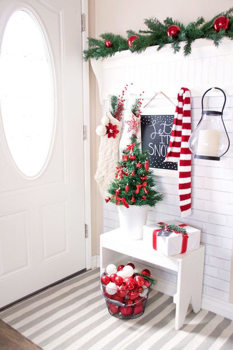 Red and white entryway decorations small Christmas tree, lamp, gift, and sign board. 