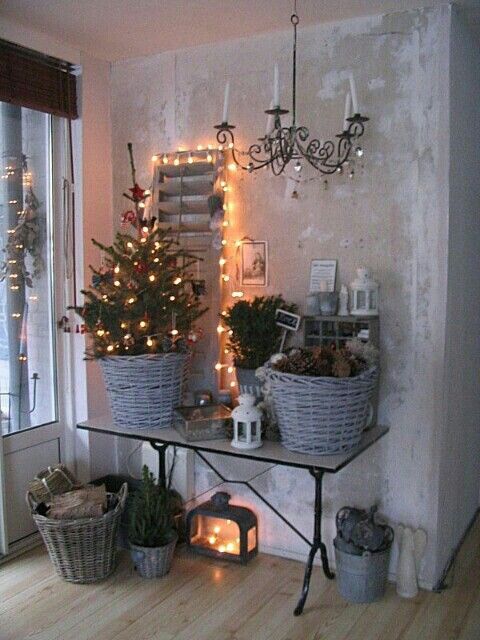 Rustic Christmas decoration with a small Christmas tree, chandelier, and lights.