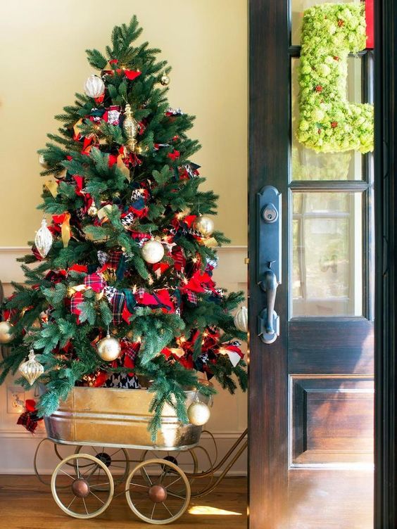 Small Christmas tree decorated with silver, golden ornaments, and plaid fabric + fresh square shape garland at door