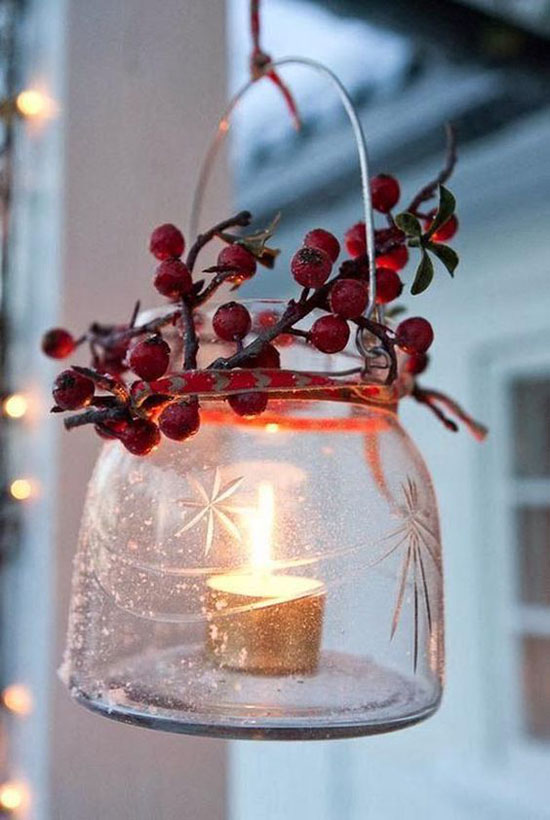 Small glass lantern decorated with red berries.