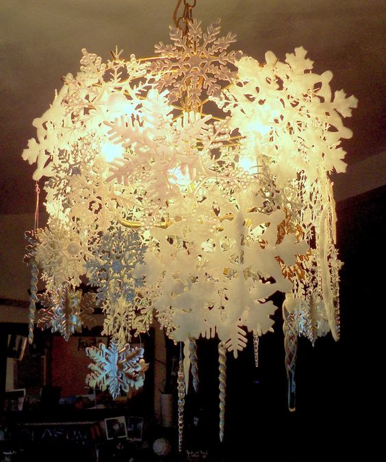 Snowflakes hanging from chandelier.