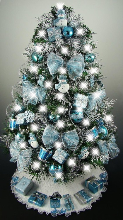 This tabletop Christmas tree is decorated with a bow, snowflakes, a drum, balls, and lead.