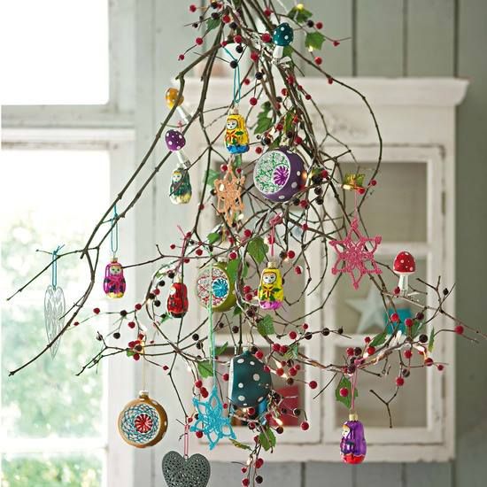 Tree branches with colorful ornaments and pom poms.