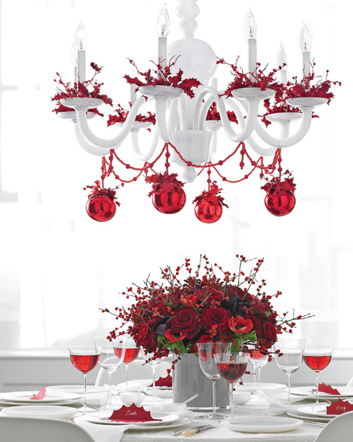 White chandelier decorated with cranberries and red ornaments.