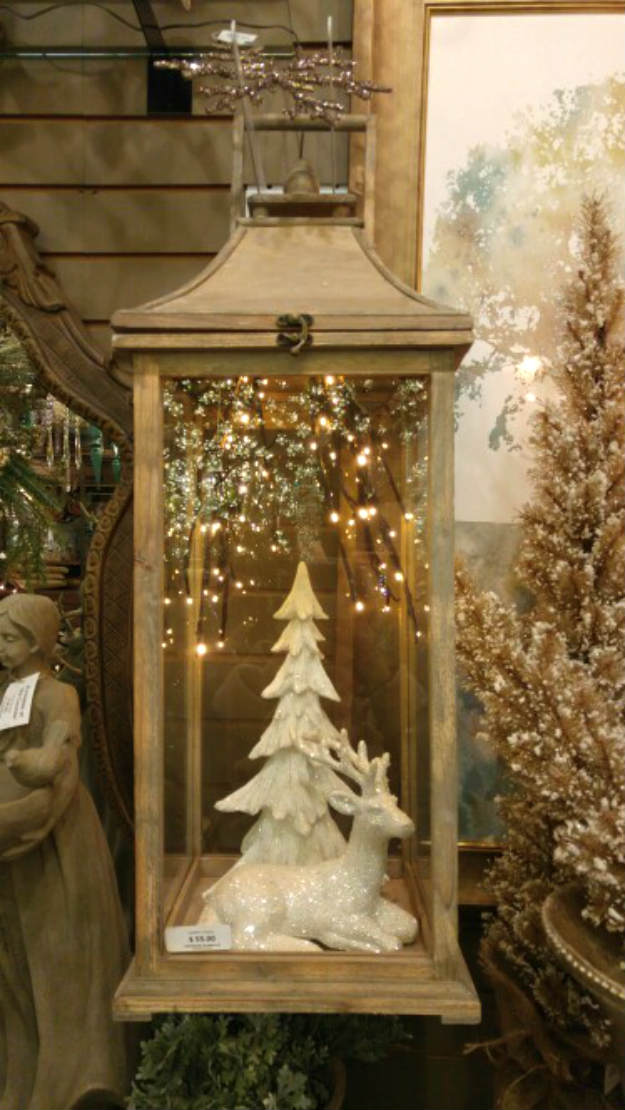 Wooden lantern with a white tree and reindeer.