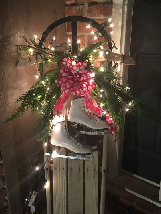 Beautiful old wooden sled decor made with fresh greenery, lights & children’s ice skates