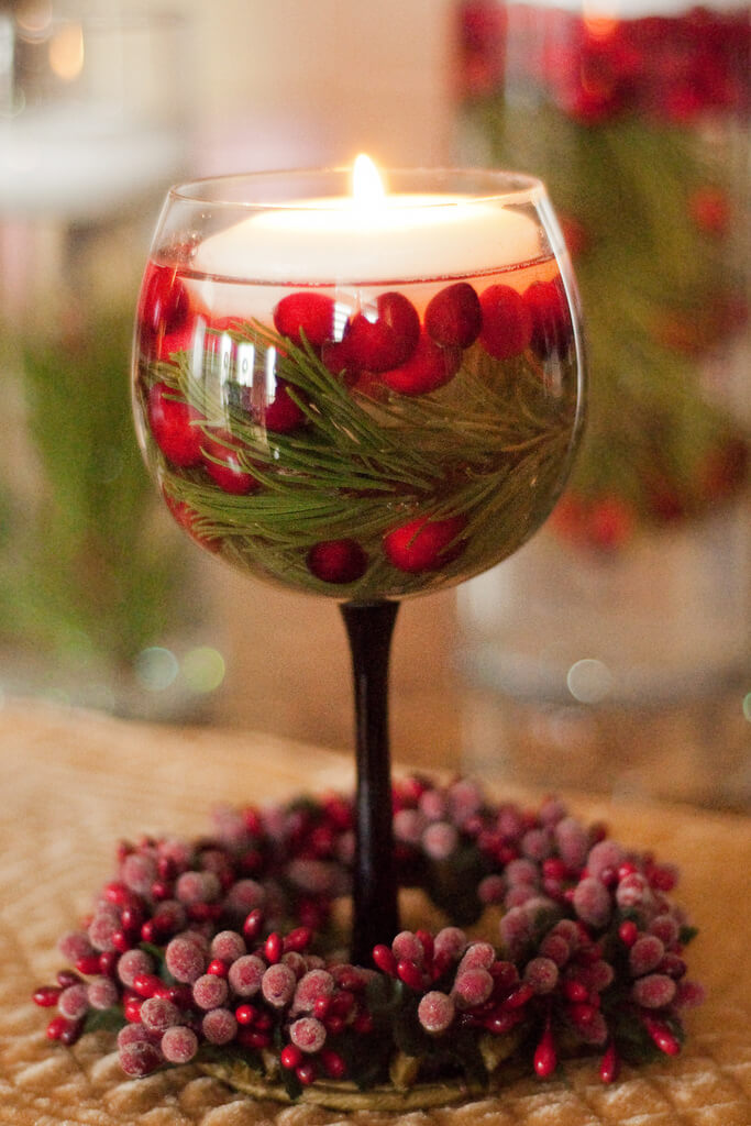 Floating candle wine glass filled with cherries.