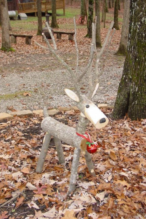 Little reindeer made of firewood with ribbon and jingle bell