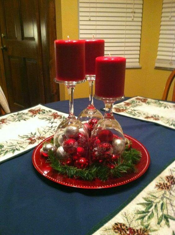 Red and silver ornament in wine glass used as candle holder for Christmas decor