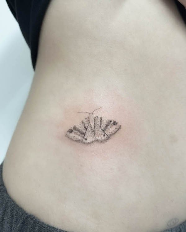 Simple small moth waist tattoo